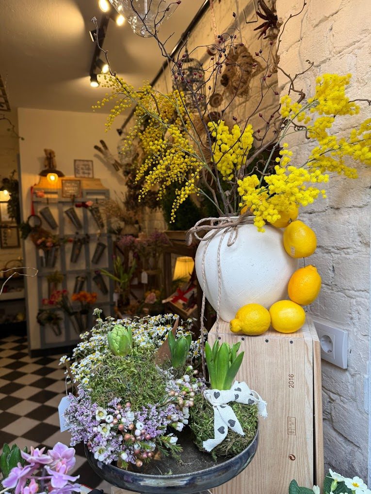 Bright mimosa arrangement with lemons inside the shop