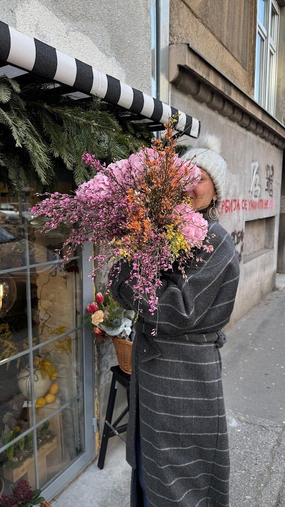 Customer holding a large pink bouquet outside Chez Gizza